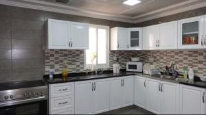 迪拜PRIVATE ROOM WITH WASHROOM AND BALCONY的厨房配有白色橱柜和水槽