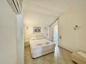 费特希耶Sunset beach club Fethiye 3 bedroom apartment的白色的卧室设有白色的床和窗户。