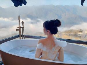 萨帕HOTEL DE SAPA的坐在浴缸中的女性,享有美景