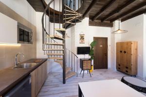 马拉加Apartamentos Simba的一间带螺旋楼梯的厨房和一间客厅
