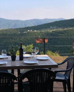 MskhaldidiPrivate Cottage in Tbilisi Area - Napetvrebi Hills的一张带酒杯和一瓶葡萄酒的木桌