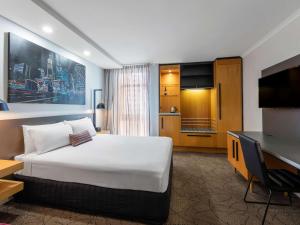 布里斯班布里斯班乔治国王广场美居酒店的酒店客房设有一张大床和一台电视。