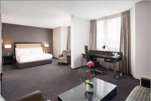 卢森堡卢森堡希尔顿逸林酒店的配有一张床和一张书桌的酒店客房