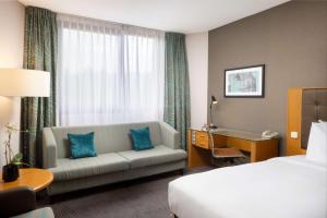 卢森堡卢森堡希尔顿逸林酒店的酒店客房设有沙发、床和书桌