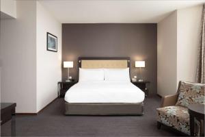 卢森堡卢森堡希尔顿逸林酒店的卧室配有白色的床和椅子