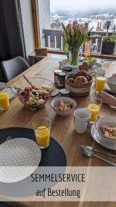 米森-维尔哈姆斯Ferienwohnung Alpenflair mit Pool und Sauna & direkt am Skilift的一张带早餐食品和橙汁的木桌