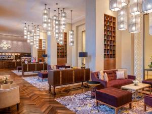 多哈Alwadi Hotel Doha - MGallery的带沙发、椅子和吊灯的图书馆