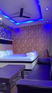 巴特那Relax Zone的一间设有一张床、一张桌子和紫色灯的房间