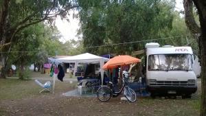 拉默齐亚泰尔默Camping Ulisse Calabria的一辆自行车停在一辆卡车旁边的伞下