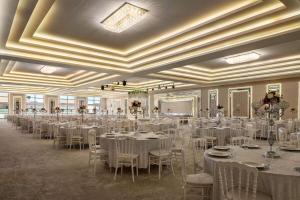 伯萨Ramada by Wyndham Karacabey的宴会厅配有白色的桌椅