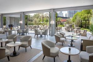 迪拜Kempinski The Boulevard Dubai的餐厅设有桌椅和窗户。