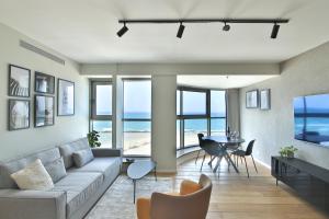 海法Luxury Suites by Notaly Ariel - Carmel Beach的客厅配有沙发和桌椅