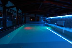 FótBarackos Wellness Villa Fót的一个夜晚有蓝色灯光的空游泳池