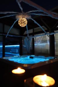 FótBarackos Wellness Villa Fót的浴室设有蓝色浴缸、灯和蜡烛