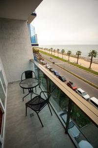 巴统Hotel Black Sea的高速公路上带桌子和汽车的阳台