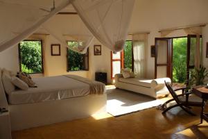 米查维Dar Beach House - Michamvi的一间卧室配有一张床、一张沙发和窗户。