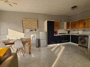 弗里敦Remarkable 3-Bed House in Freetown的一间带桌子和冰箱的大厨房
