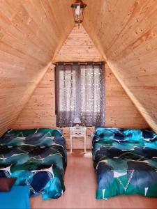 克卢日-纳波卡Moara de Pădure的小木屋内带两张床的房间