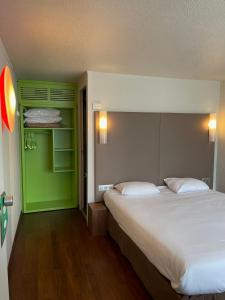 圣维克托蒙吕松〜圣 - 维克多钟楼酒店的一间卧室设有一张大床和绿色的墙壁