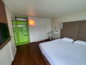 圣维克托蒙吕松〜圣 - 维克多钟楼酒店的卧室配有白色的床和绿门