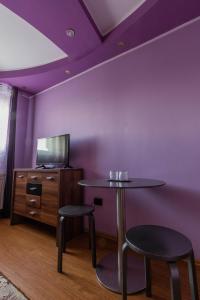 加拉茨Vila Mario的紫色的房间,配有一张桌子和两张凳子