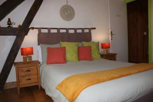 FaverollesL'autre Monde的一间卧室配有一张带色彩缤纷枕头的大床