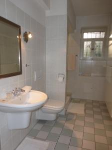 汉诺威托斯卡别墅酒店的白色的浴室设有水槽和卫生间。