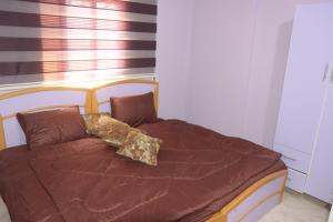 Aş ŞāfīWalaa Chalet的一张带棕色毯子和枕头的床