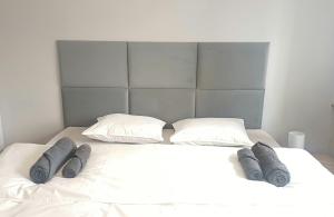 克拉科夫Matylda House的一张带两个枕头和三条灰色毯子的白色床