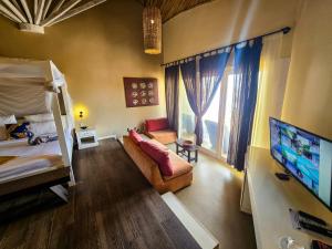 科洛里Balafon Beach Resort的一间卧室配有双层床、沙发和电视。