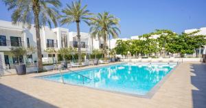 富查伊拉Luxury Villa by the sea的一座棕榈树和建筑游泳池