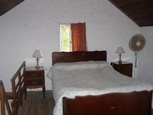 巴拉德瓦利扎斯Lambae的一间卧室配有一张床和两个带灯的床头柜