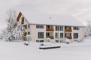 韦斯灵Ferienwohnungen Gut Mischenried的一座白色的大建筑,地面上积雪
