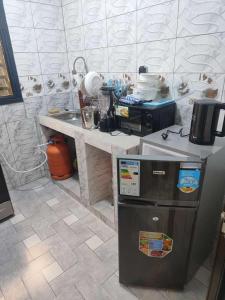 瓦加杜古As résidence meublée AM的厨房配有柜台和冰箱。