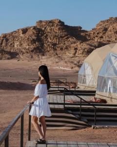 瓦迪拉姆Rum Mars camp的站在沙漠台阶上的身着白色衣服的妇女