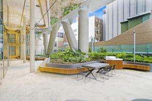 悉尼Sydney CBD Luxury Furnished Apartment & City Views的大楼内带桌椅的庭院