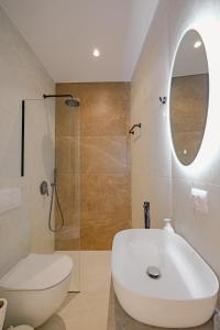 萨兰达Villa Xhefri 2的一间带水槽、卫生间和镜子的浴室