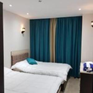 赫尔格达ميراج باي (شاليه)的一间卧室设有两张床和蓝色窗帘