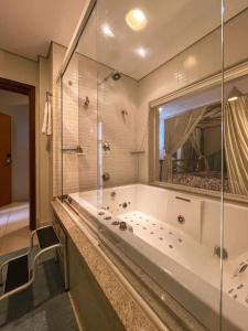 特雷斯拉瓜斯泰姬酒店的带浴缸和玻璃墙的大型浴室