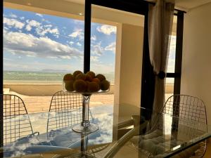 斯特兰德Loddey's Self Catering Apartments - by Beach Collection的窗户前玻璃桌上的一碗水果