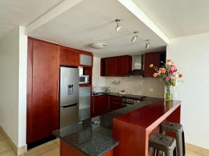 斯特兰德Loddey's Self Catering Apartments - by Beach Collection的厨房配有红色橱柜和黑色台面