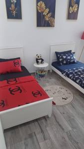 奥兰Fernand ville oran的一间卧室配有两张床和一张桌子,铺有地毯。
