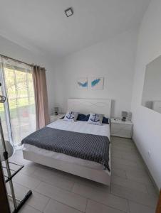 Faja GrandeOceanus的白色的卧室设有床和窗户
