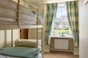 德拉姆纳德罗希特Bridgend House B&B的一间卧室设有两张双层床和一扇窗户。