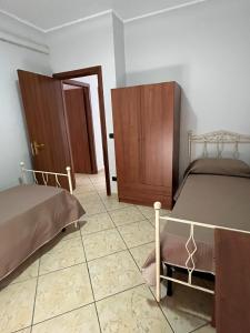 蒙德拉戈内Casa Sofia的一间卧室设有两张床和木制橱柜