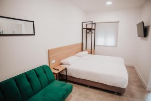 ZaratánPolorooms的一间卧室配有一张床和一张绿色沙发