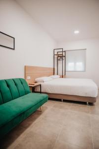 ZaratánPolorooms的一间卧室配有两张床和一张绿色沙发