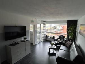 库克斯港Frische Brise Ferienwohnung mit Meerblick的带沙发和平面电视的客厅