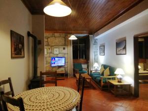 Alvoco da Serra蓬特旅馆的客厅配有桌子和沙发
