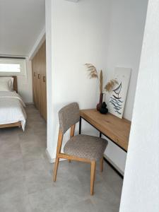 希俄斯MYROVOLOS APARTMENTS的一间卧室配有书桌、椅子和床